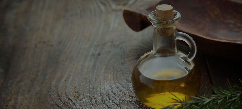 A glass cruet of oil against a wooden table